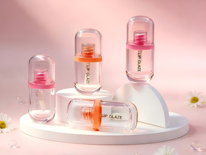 Clear capsule-shaped empty lip gloss tube with custom colored collar for lip glaze cosmetic packaging.